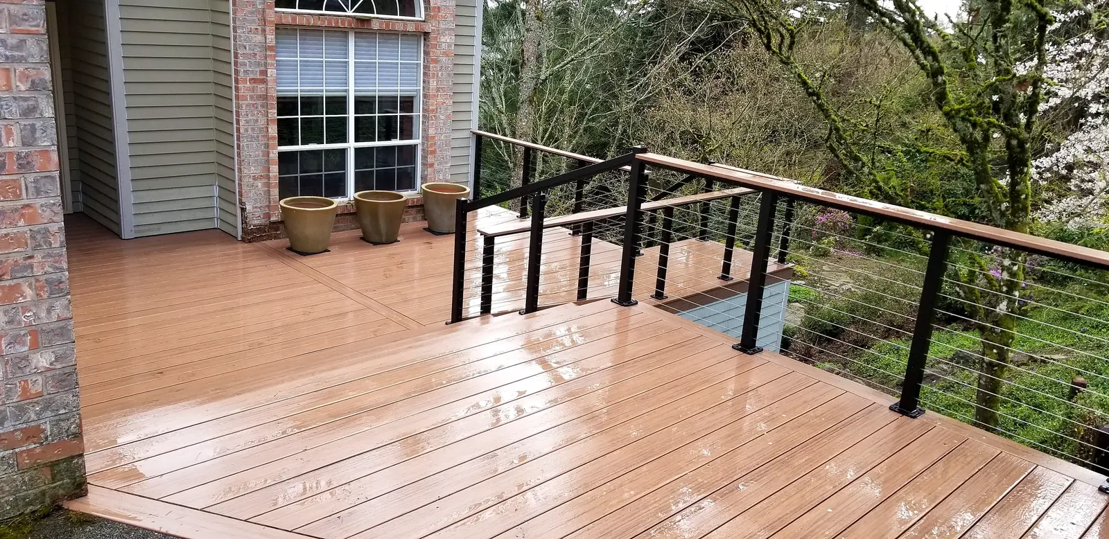 Composite deck with cable railing overlooking a wooded backyard