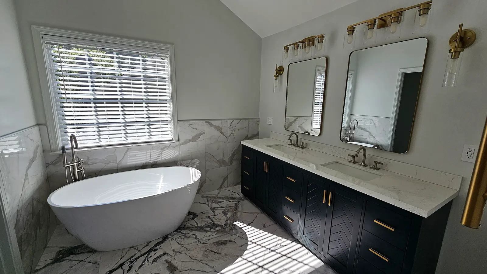 Double vanity with dark blue cabinetry and marble countertop